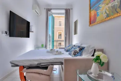 a bed in a room with a table and a window at LE FELIX au cœur du centre-ville, emplacement idéal pour loisirs ou congrès in Cannes