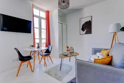a living room with a couch and a table at LA PANTHERE studio design central et calme, idéal pour un séjour en couple ou congrès in Cannes