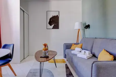 a living room with a blue couch and a table at LA PANTHERE studio design central et calme, idéal pour un séjour en couple ou congrès in Cannes
