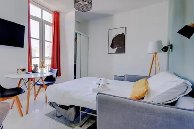 a bedroom with a bed and a table in a room at LA PANTHERE studio design central et calme, idéal pour un séjour en couple ou congrès in Cannes