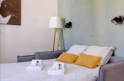 a bedroom with a bed with two towels on it at LA PANTHERE studio design central et calme, idéal pour un séjour en couple ou congrès in Cannes