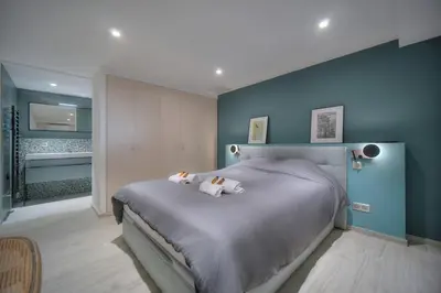 a bedroom with a large bed with a blue wall at Beau 2 chambres TERRASSE, JARDIN, Picaud- Proche Plages MIDI A2B241 in Cannes