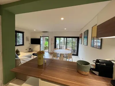 a kitchen and living room with a wooden table at Beau 2 chambres TERRASSE, JARDIN, Picaud- Proche Plages MIDI A2B241 in Cannes