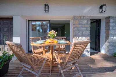a wooden table and chairs on a patio at Beau 2 chambres TERRASSE, JARDIN, Picaud- Proche Plages MIDI A2B241 in Cannes