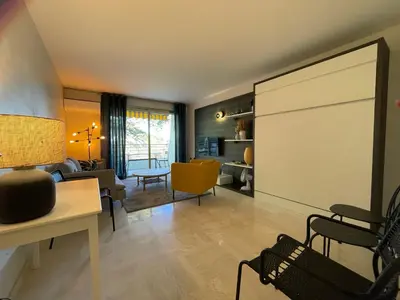a living room with a large screen in the middle of the room at C012-Appartement confortable avec piscine, tennis et grand parc in Cannes