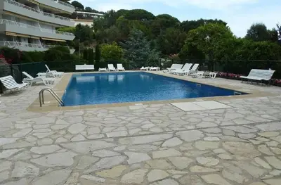 a large swimming pool with chairs and a building at C012-Appartement confortable avec piscine, tennis et grand parc in Cannes