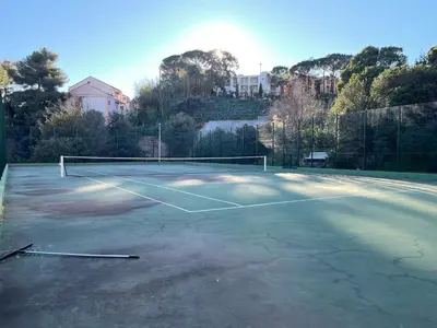 a tennis court with a net on it at C012-Appartement confortable avec piscine, tennis et grand parc in Cannes