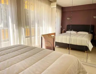 a bedroom with a bed and a large window at C012-Appartement confortable avec piscine, tennis et grand parc in Cannes