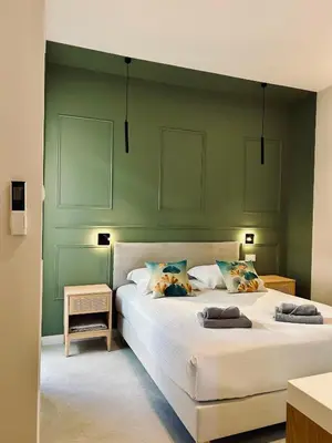 a bedroom with a large bed with a green wall at KOSY Spa, Les Princes in Cannes