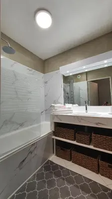 a bathroom with a sink and a large mirror at Mélodie Garage Gratuit in Cannes