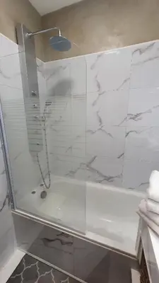 a bathroom with a shower with a glass door at Mélodie Garage Gratuit in Cannes