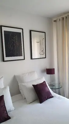 a bedroom with a bed and two pictures on the wall at Mélodie Garage Gratuit in Cannes