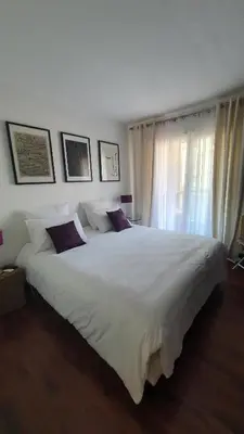 a large white bed in a bedroom with a window at Mélodie Garage Gratuit in Cannes