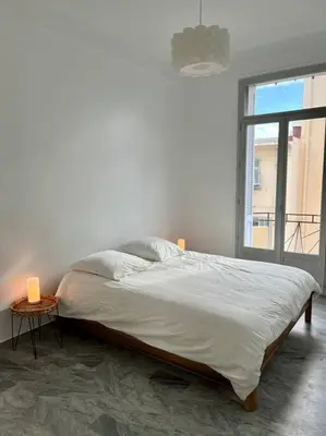 a bed in a white room with a window at T2 Cannes centre - Appartement cosy proche Palais in Cannes