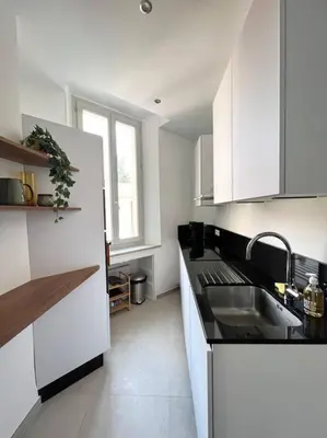 a white kitchen with a sink and a counter top at T2 Cannes centre - Appartement cosy proche Palais in Cannes
