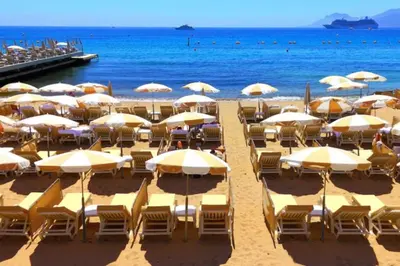 a beach with chairs and umbrellas and the ocean at Cannes Heart of town 2 BR perfect congress & Holidays by Olam Properties in Cannes