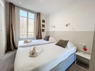 two beds in a room with a window at Cannes Heart of town 2 BR perfect congress & Holidays by Olam Properties in Cannes