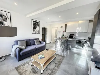 a living room with a couch and a table at Cannes Croisette Rue Meynadier Palais 1 mn Modern 1 BR by Olam Properties in Cannes