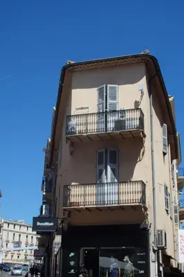 a building with a balcony on the side of it at Cannes Croisette Rue Meynadier Palais 1 mn Modern 1 BR by Olam Properties in Cannes