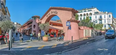 a building with an arch on a city street at Cannes Croisette Rue Meynadier Palais 1 mn Modern 1 BR by Olam Properties in Cannes