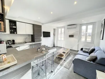 a living room with a blue couch and a kitchen at Cannes Croisette Rue Meynadier Palais 1 mn Modern 1 BR by Olam Properties in Cannes