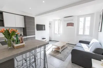 a kitchen and living room with a couch and a table at Cannes Croisette Rue Meynadier Palais 1 mn Modern 1 BR by Olam Properties in Cannes