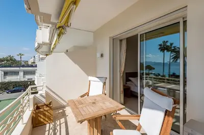 a balcony with a wooden table and two chairs at Buckingham & Lloyds - Cannes in Cannes