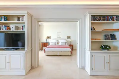 a bedroom with a bed and a flat screen tv at Buckingham & Lloyds - Cannes in Cannes