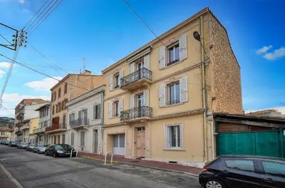 a building with cars parked on the side of a street at KosyKasa SPA in Cannes