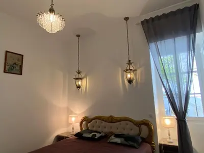 a bedroom with a bed and lights and a window at HEART OF OLD TOWN - BEACH 150m & PALAIS DES FESTIVALS 600m in Cannes