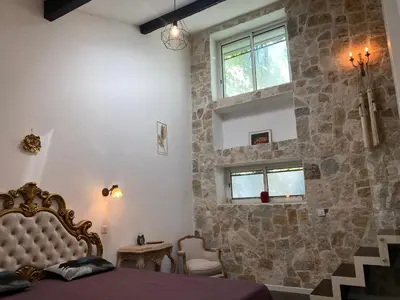 a bedroom with a bed and a stone wall at HEART OF OLD TOWN - BEACH 150m & PALAIS DES FESTIVALS 600m in Cannes