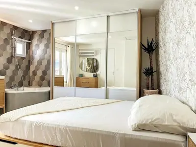 a bedroom with a large white bed and a bath tub at Cocon Forville - Palais des Festivals, Plages, clim, marché provençal, Vieux Port et Suquet in Cannes