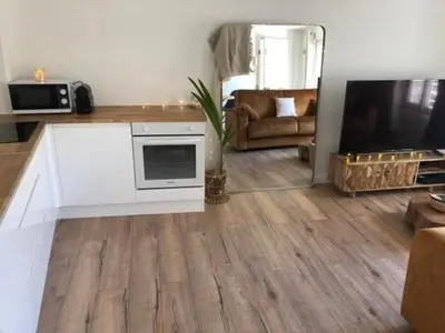 a living room with a television and a living room with a couch at Cocon Forville - Palais des Festivals, Plages, clim, marché provençal, Vieux Port et Suquet in Cannes