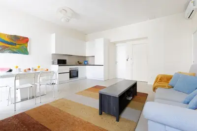 a white living room with a couch and a table at Gazagnaire YourHostHelper in Cannes