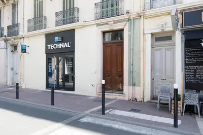 a street with a building with a wooden door at Gazagnaire YourHostHelper in Cannes