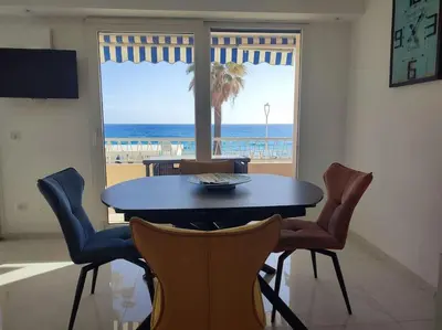 a dining room with a table and a view of the beach at Le Madrigal by Halldis in Cannes