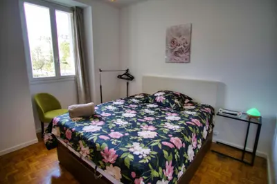 a bedroom with a bed with a floral comforter and a window at Ref SELV -Palmes d'Or Properties in Cannes