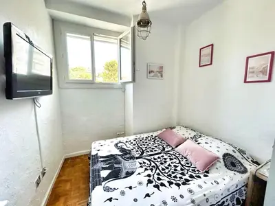 a bedroom with a black and white bed and a tv at Ref SELV -Palmes d'Or Properties in Cannes