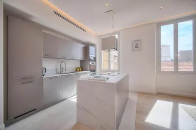 a kitchen with white cabinets and a large window at STANDING - NEUF - Croisette- Palais des festivals - 6 pers -3 chbres in Cannes