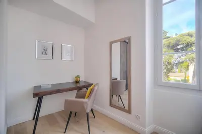 a room with a desk and a mirror and a window at STANDING - NEUF - Croisette- Palais des festivals - 6 pers -3 chbres in Cannes