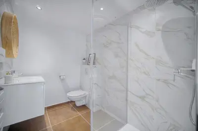 a white bathroom with a shower and a toilet at STANDING - NEUF - Croisette- Palais des festivals - 6 pers -3 chbres in Cannes