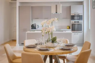 a dining room table with a vase of flowers on it at STANDING - NEUF - Croisette- Palais des festivals - 6 pers -3 chbres in Cannes