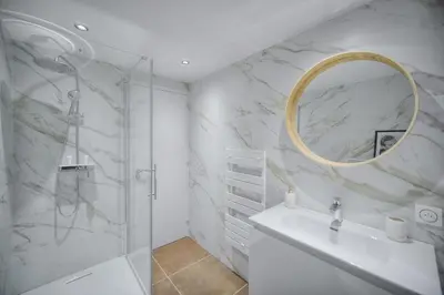 a bathroom with a shower and a sink and a mirror at STANDING - NEUF - Croisette- Palais des festivals - 6 pers -3 chbres in Cannes