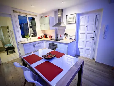 a kitchen with a table and some chairs in it at Cannes Croisette Suquet Duplex 4 P in Cannes