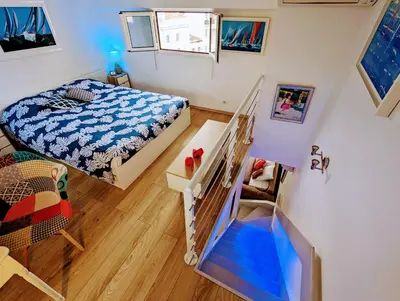 a small bedroom with a bed and a staircase at Cannes Croisette Suquet Duplex 4 P in Cannes