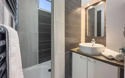 a bathroom with a sink and a mirror and a tub at Le Selvosa by Winsome Destination in Cannes
