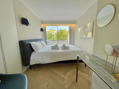 a small bedroom with a bed and a window at Cannes Appartement 3 pièces vue mer in Cannes