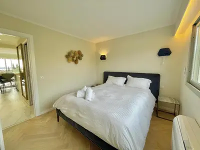a bedroom with a large bed with white sheets and pillows at Cannes Appartement 3 pièces vue mer in Cannes