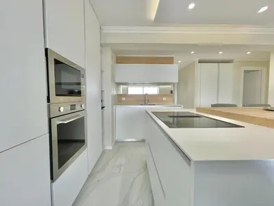 a white kitchen with a sink and a stove at Cannes Appartement 3 pièces vue mer in Cannes