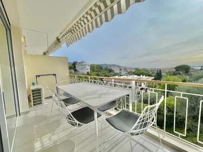 a patio with a table and chairs on a balcony at Cannes Appartement 3 pièces vue mer in Cannes